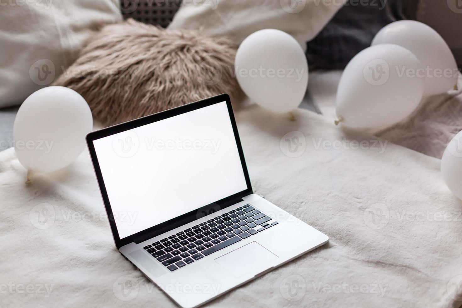 Close up laptop on the bed in morning time with soft light from window photo