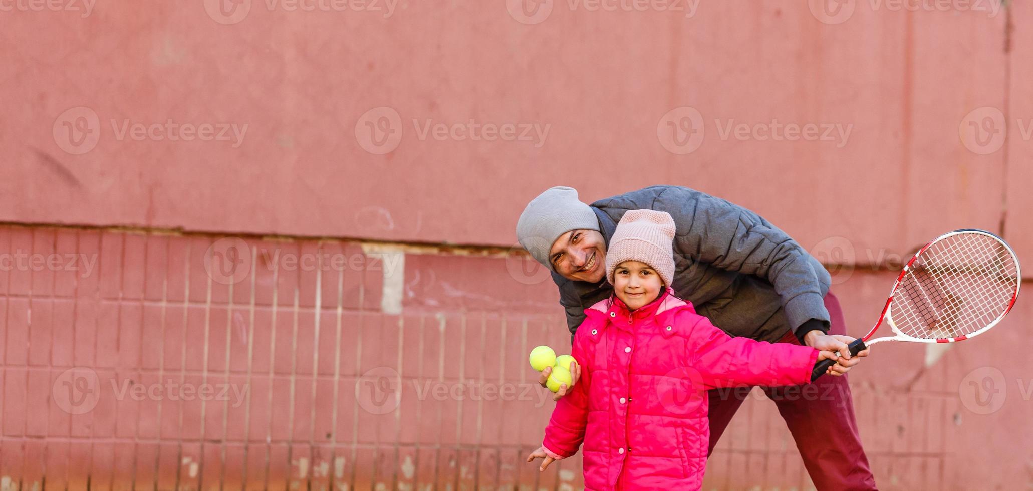 Active family playing tennis on court photo