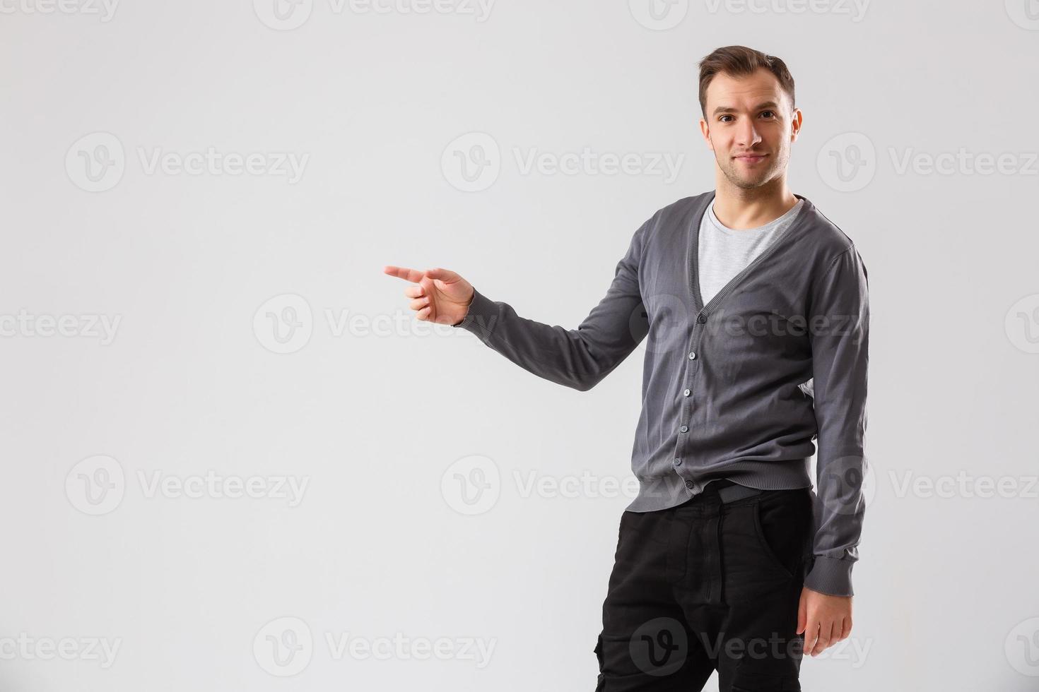 Young man presenting your product, isolated over a white background photo