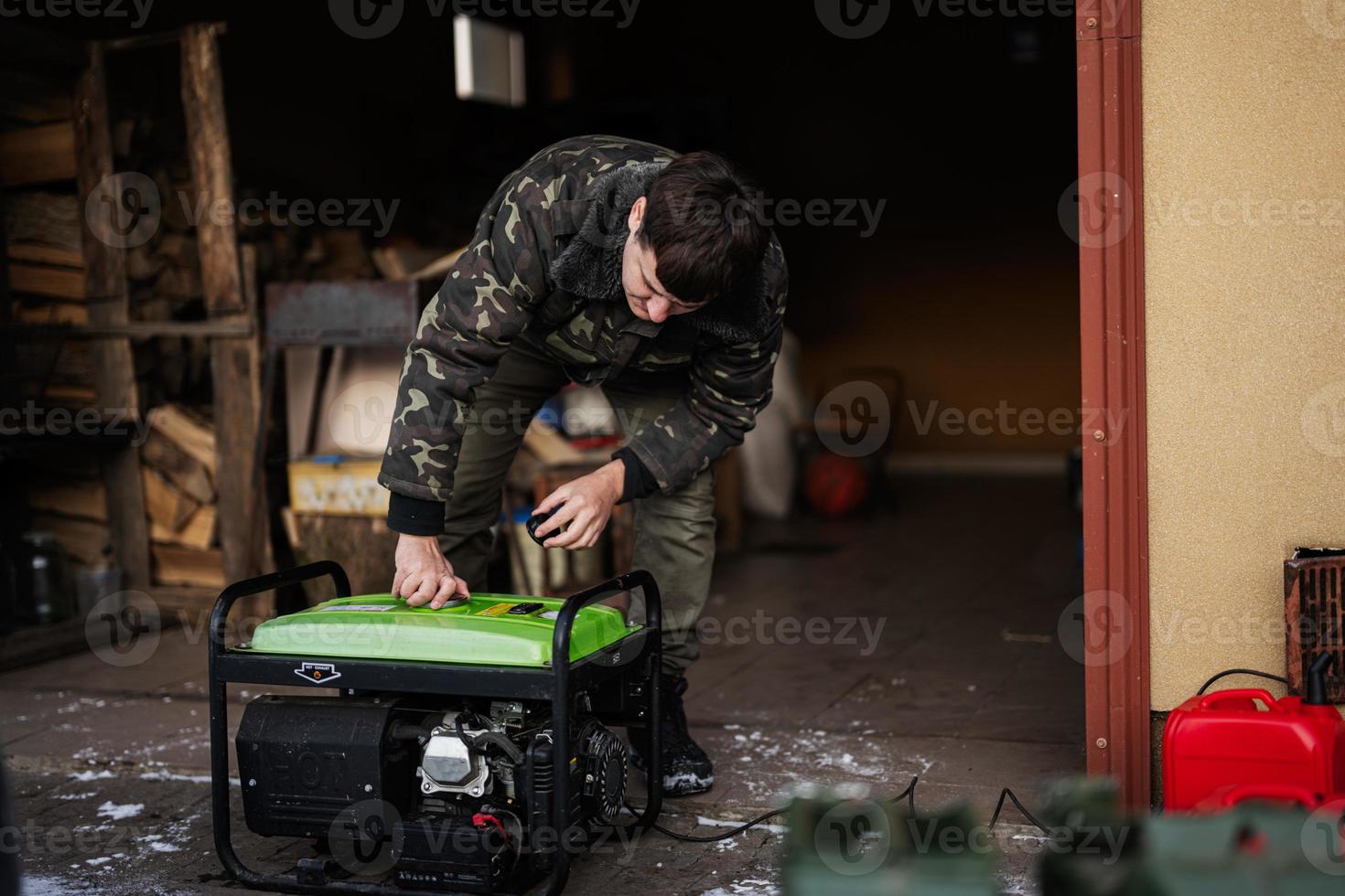 Man wear in military jacket with gasoline portable mobile backup standby generator. photo