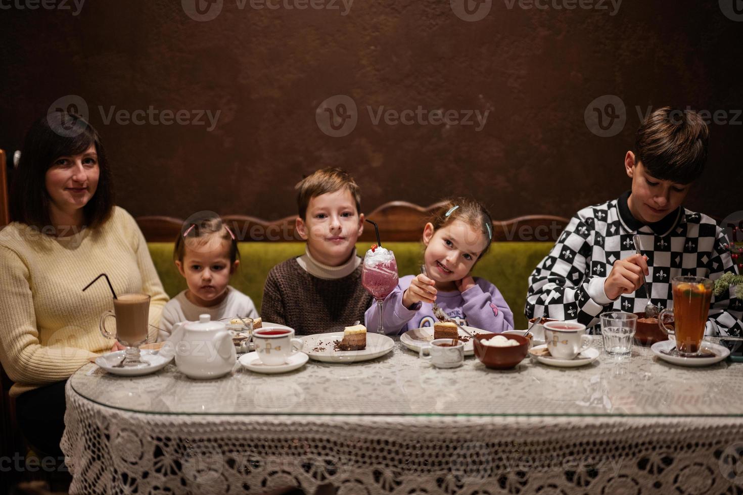 familia feliz comiendo postres juntos en un acogedor café y divirtiéndose. foto