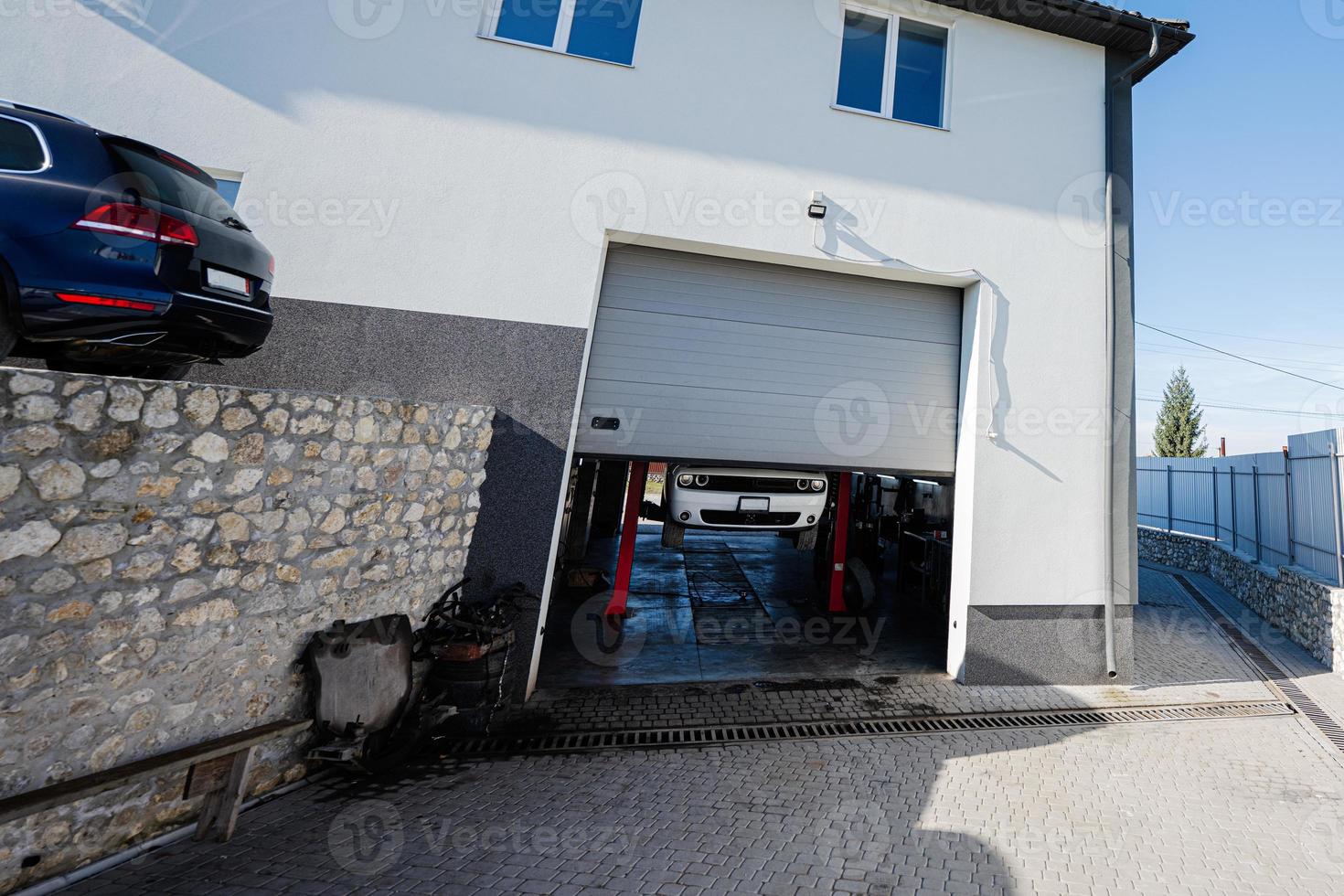 Garage gates view of muscle car at service repair station in lift. photo