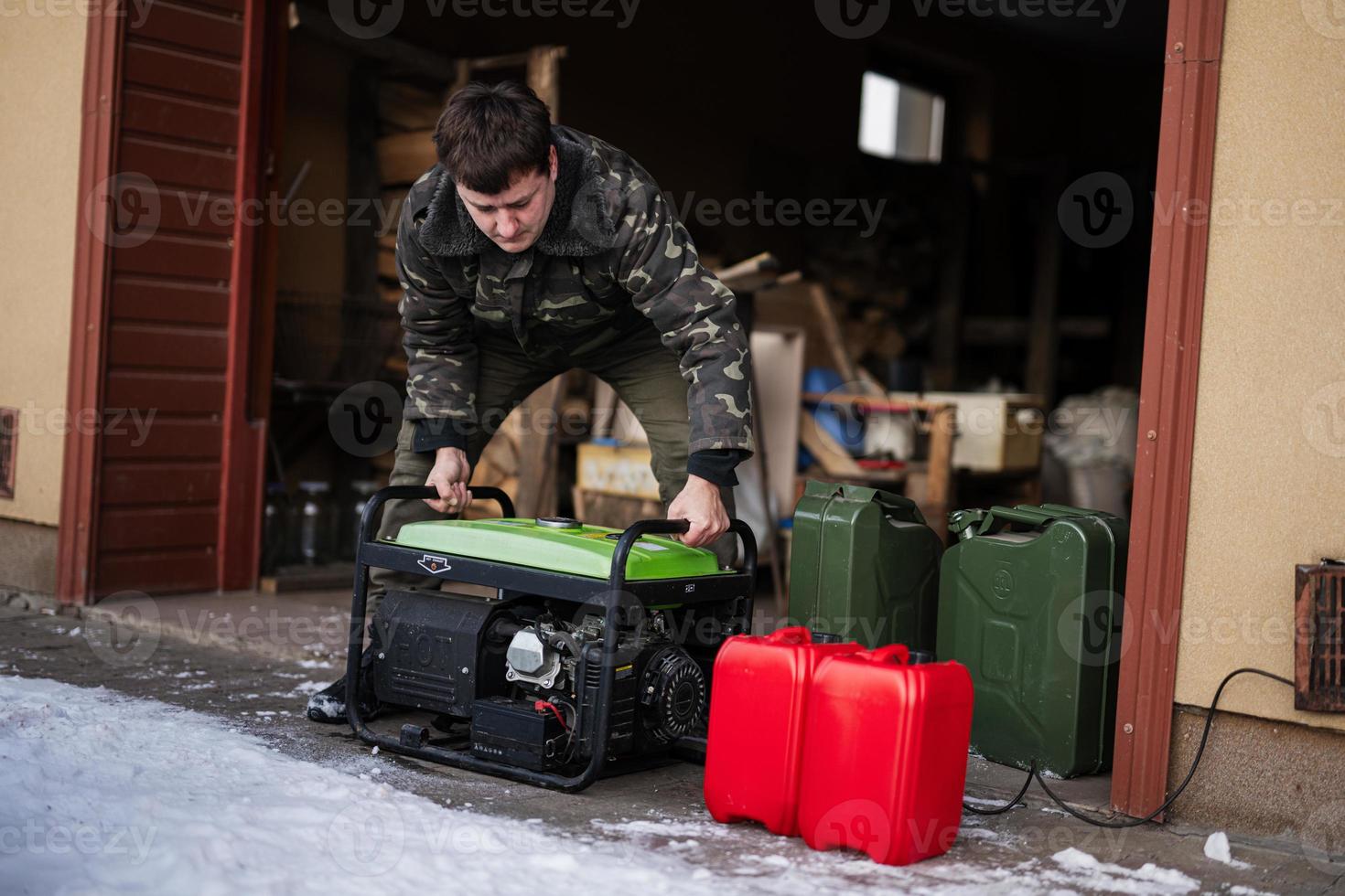 Man wear in military jacket with gasoline portable mobile backup standby generator. photo