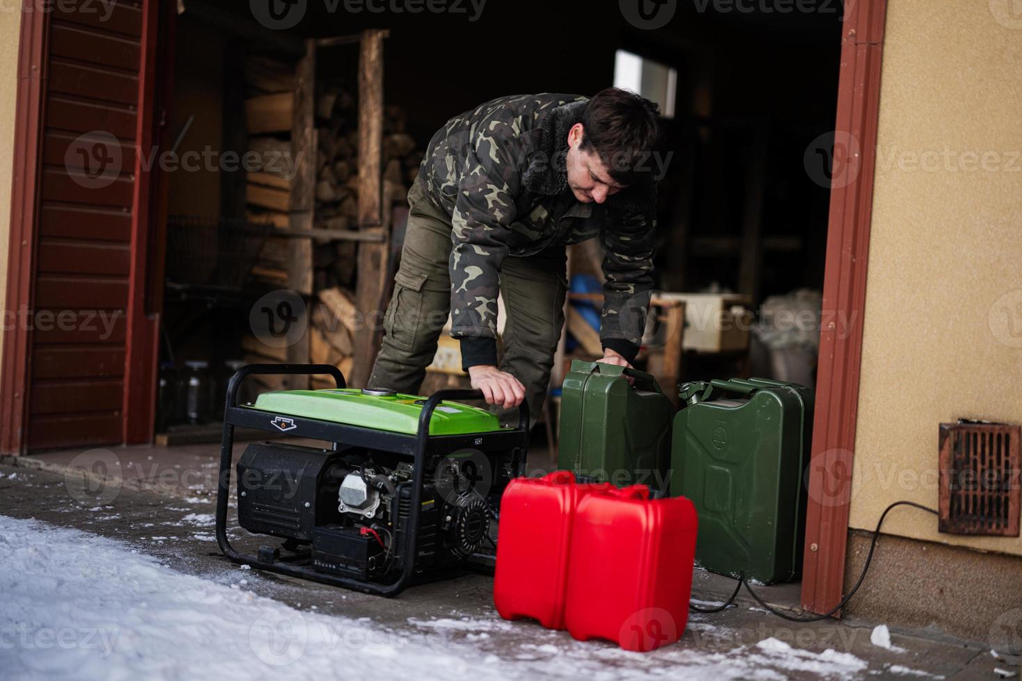 Man wear in military jacket with gasoline portable mobile backup standby generator. photo