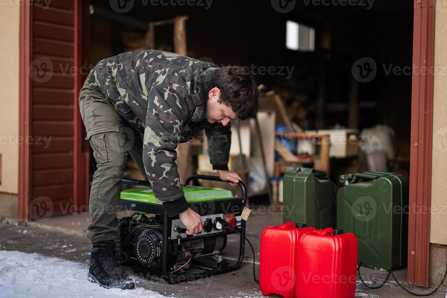 Man wear in military jacket with gasoline portable mobile backup standby generator. photo