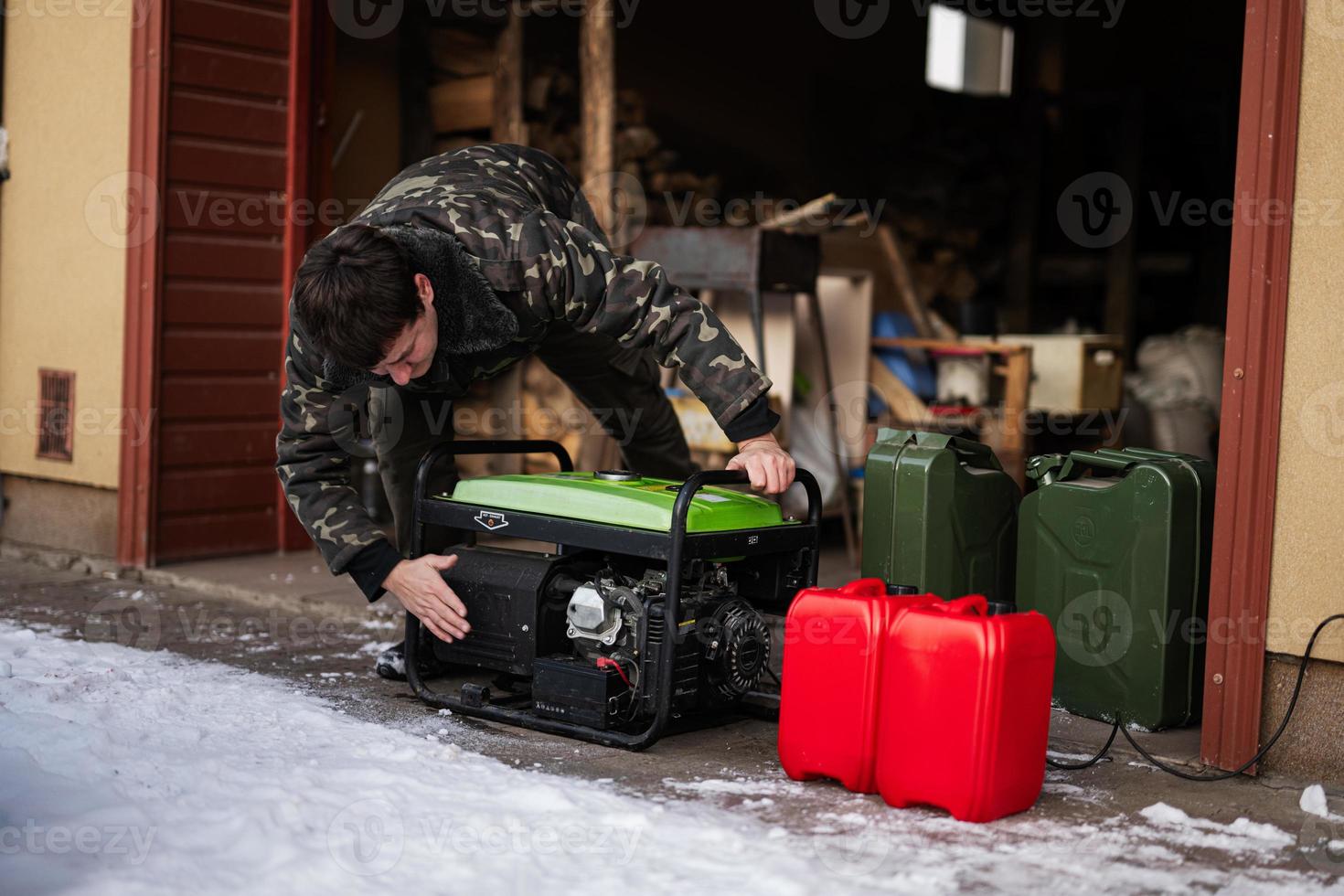 Man wear in military jacket with gasoline portable mobile backup standby generator. photo