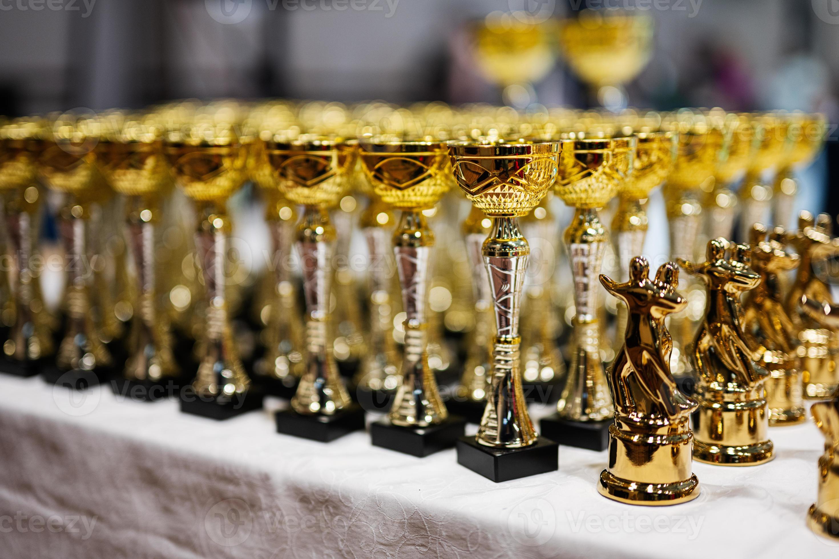 Award and victory concept. Row of golden cups of dance competition