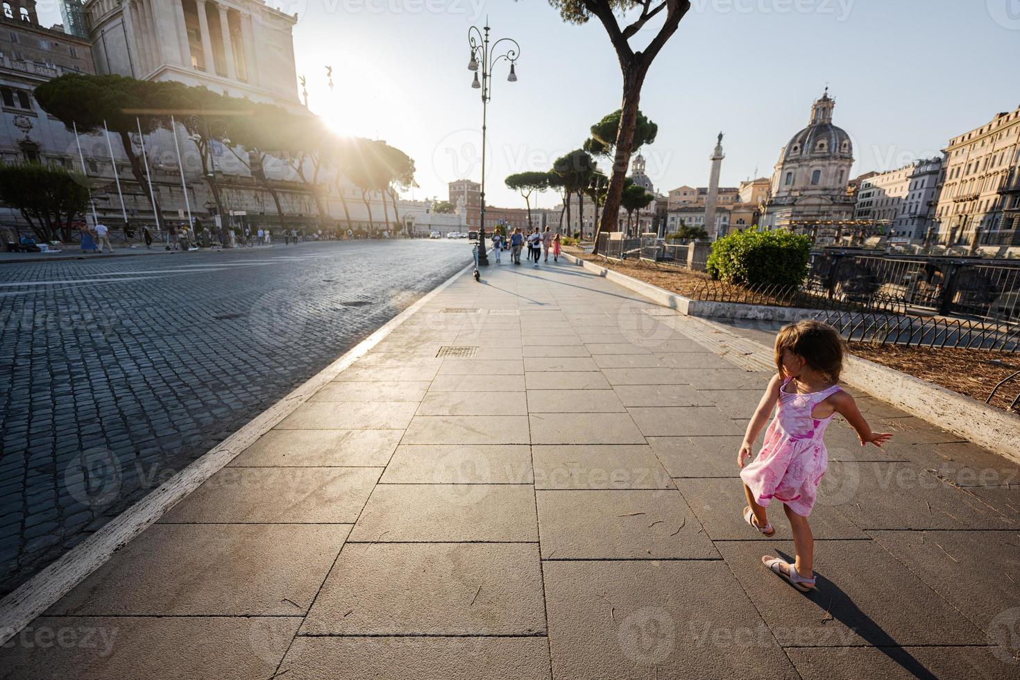 Baby girl against Santa Maria di Loreto church in Rome, Italy. photo