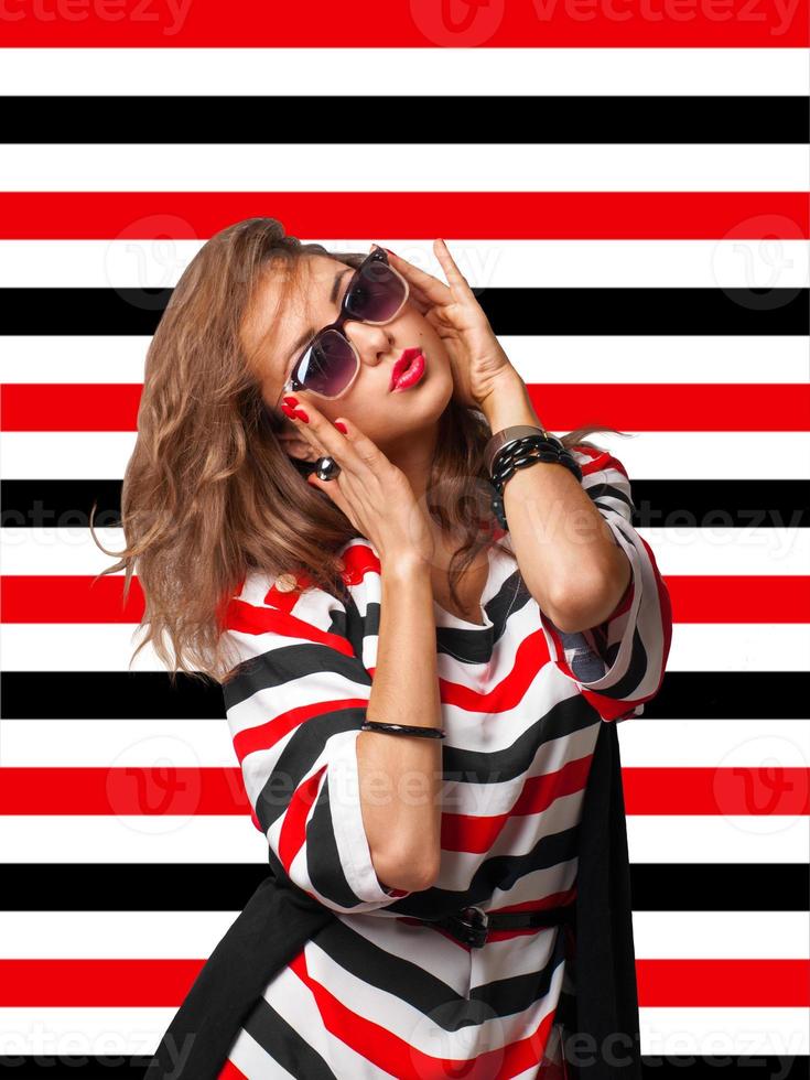 young woman in sunglasses on stripes background photo