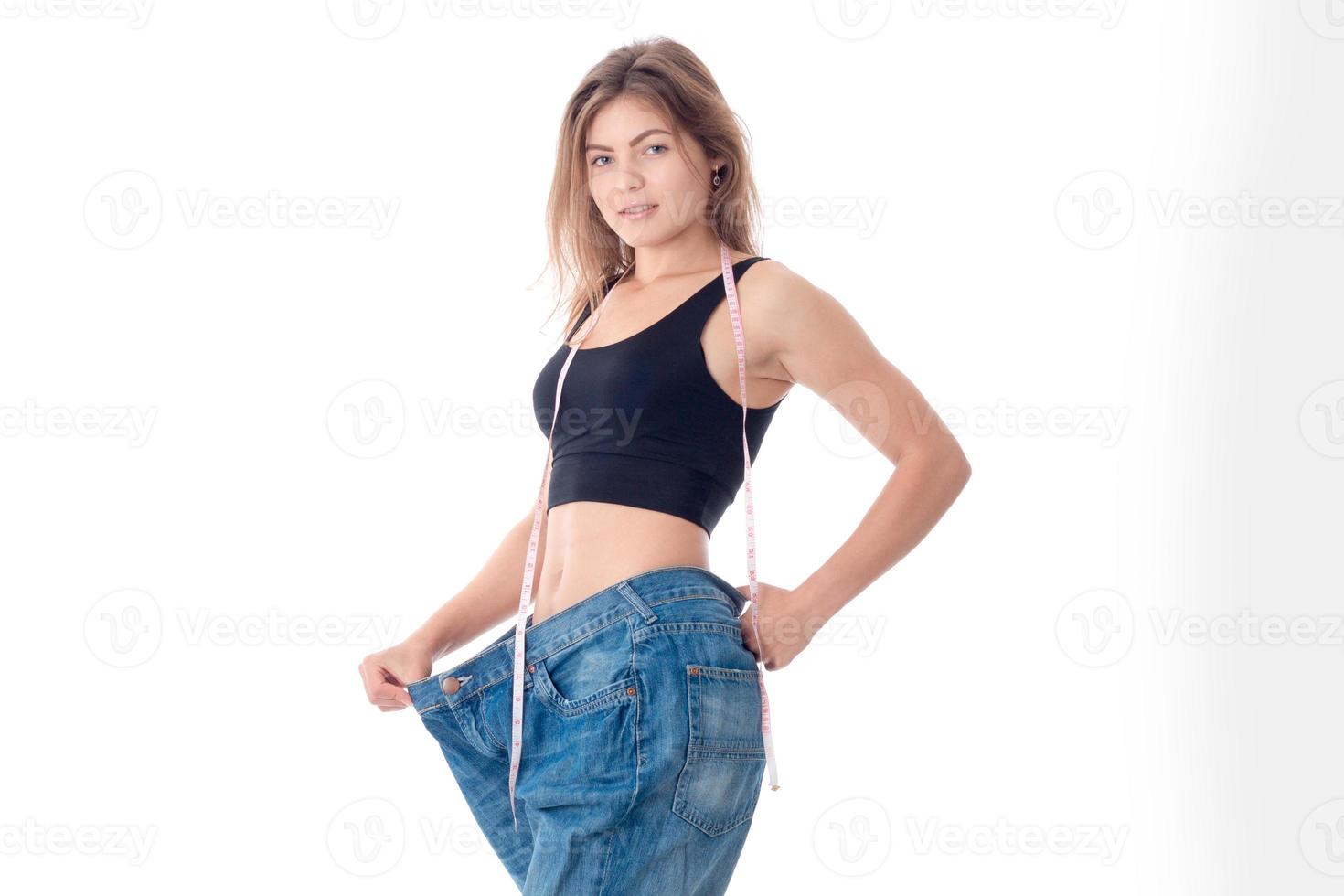 Slim athletic girl stretches hand big wide pants isolated on white background photo