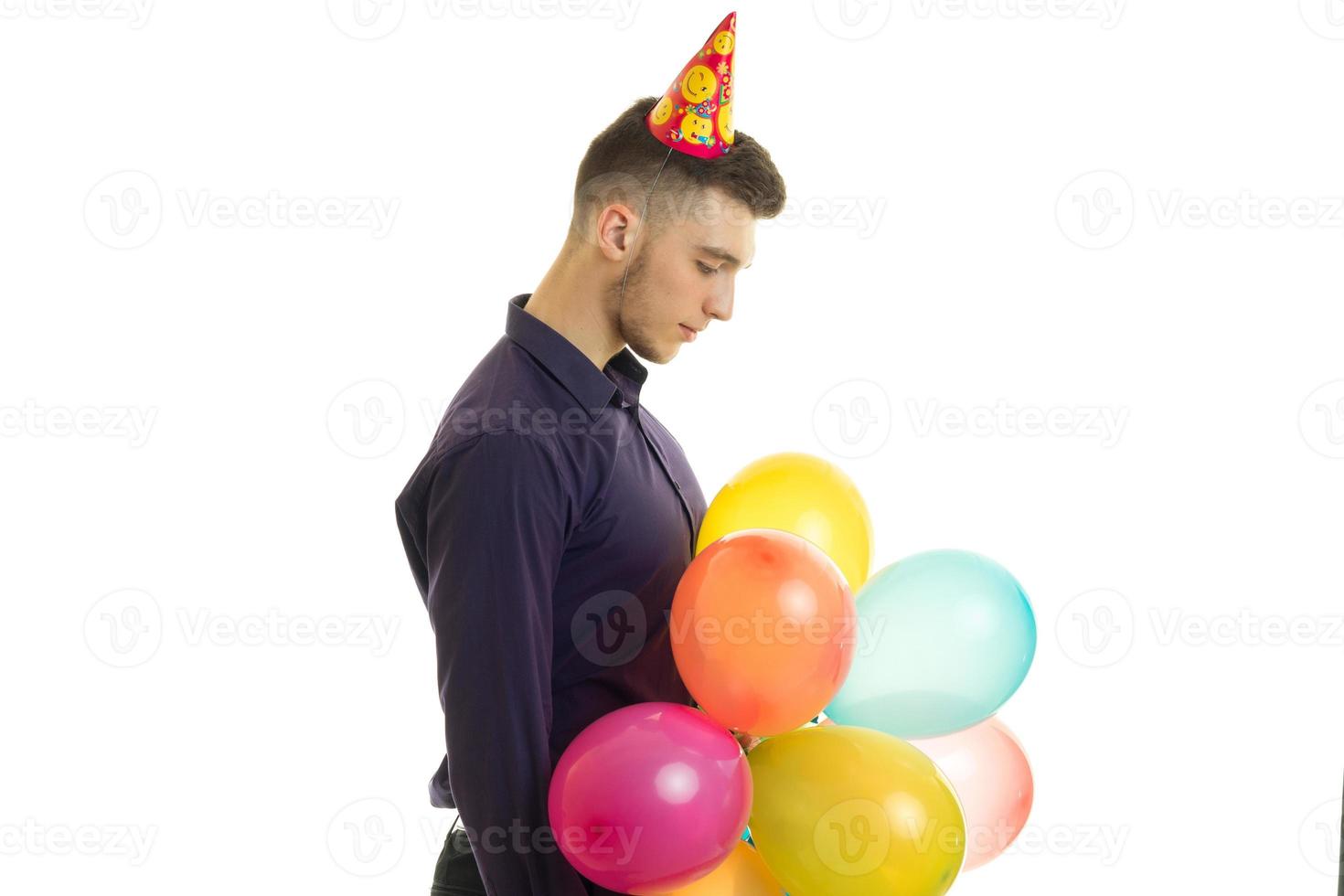 young guy stands in the Studio and holds a lot of balloons photo