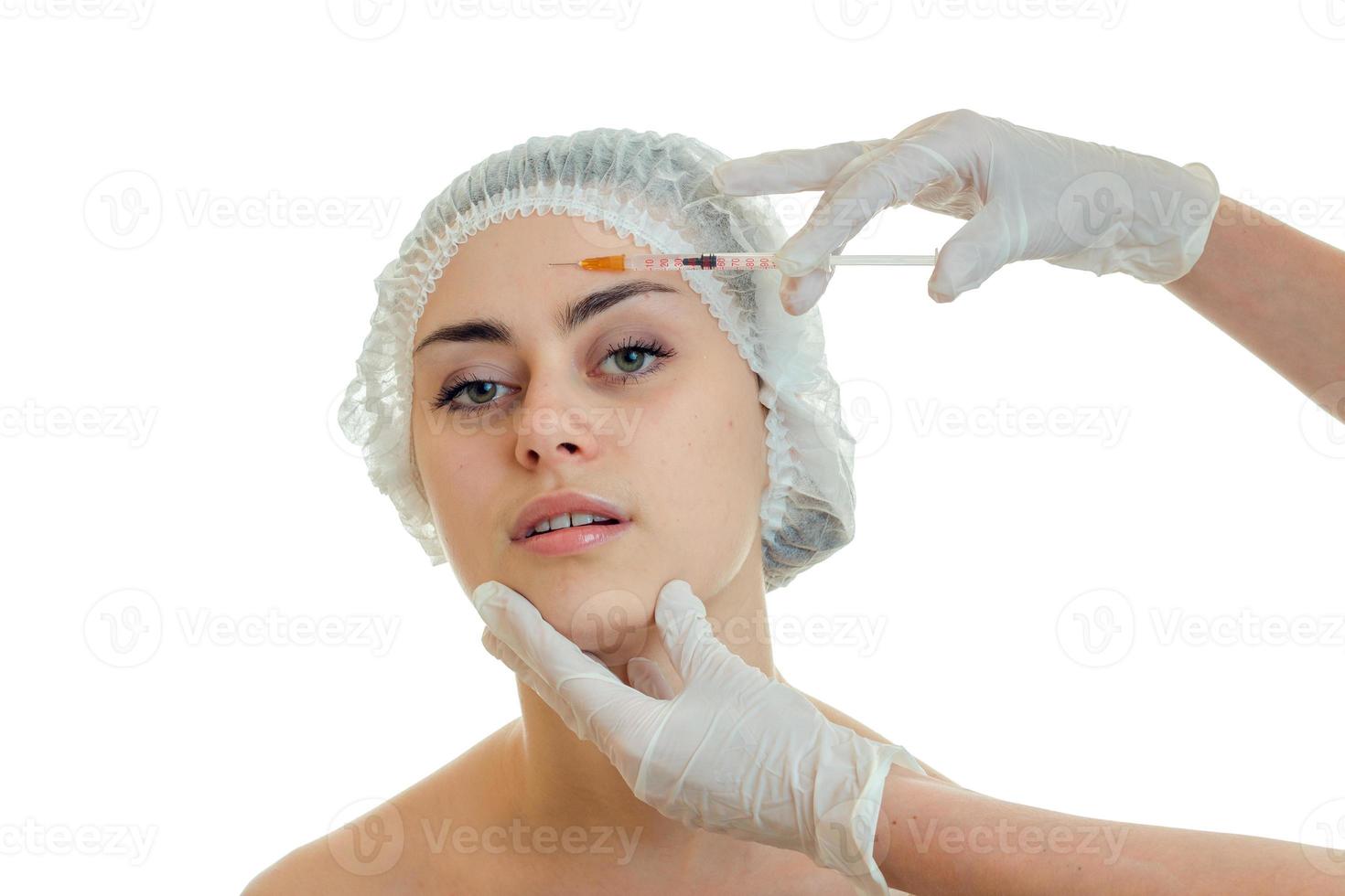 horizontal portrait of a young girl at the doctor who gloved introduces vaccine on face photo