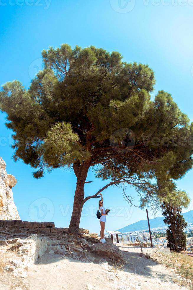 girl in the ruins of an ancient Acropolis under a big tree photo