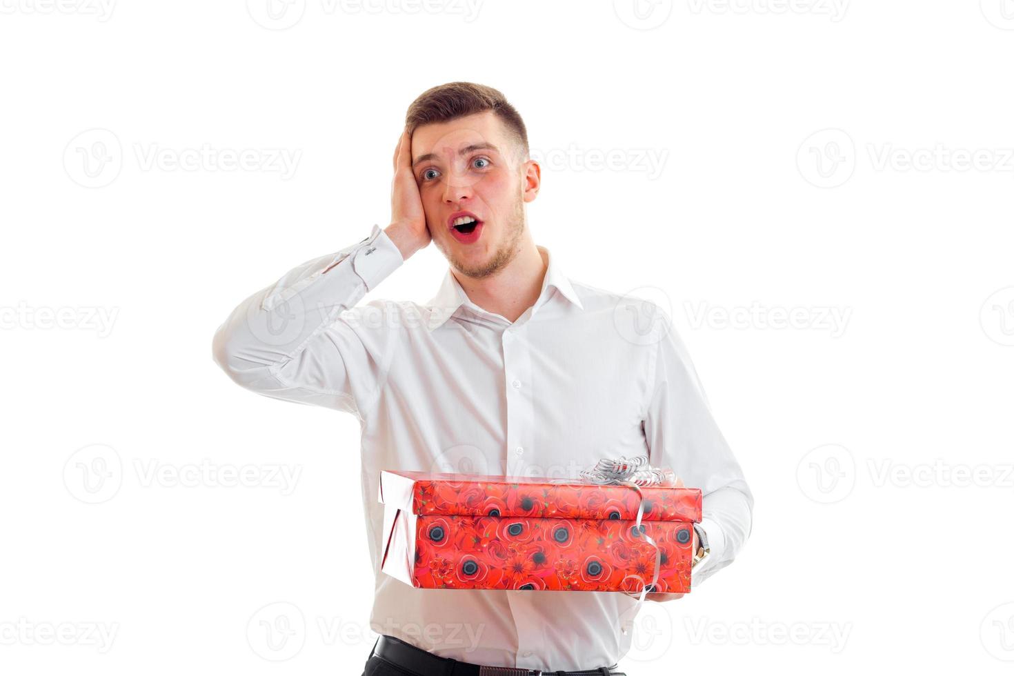surprised a young guy with a gift and opened my mouth with his hand behind his head photo