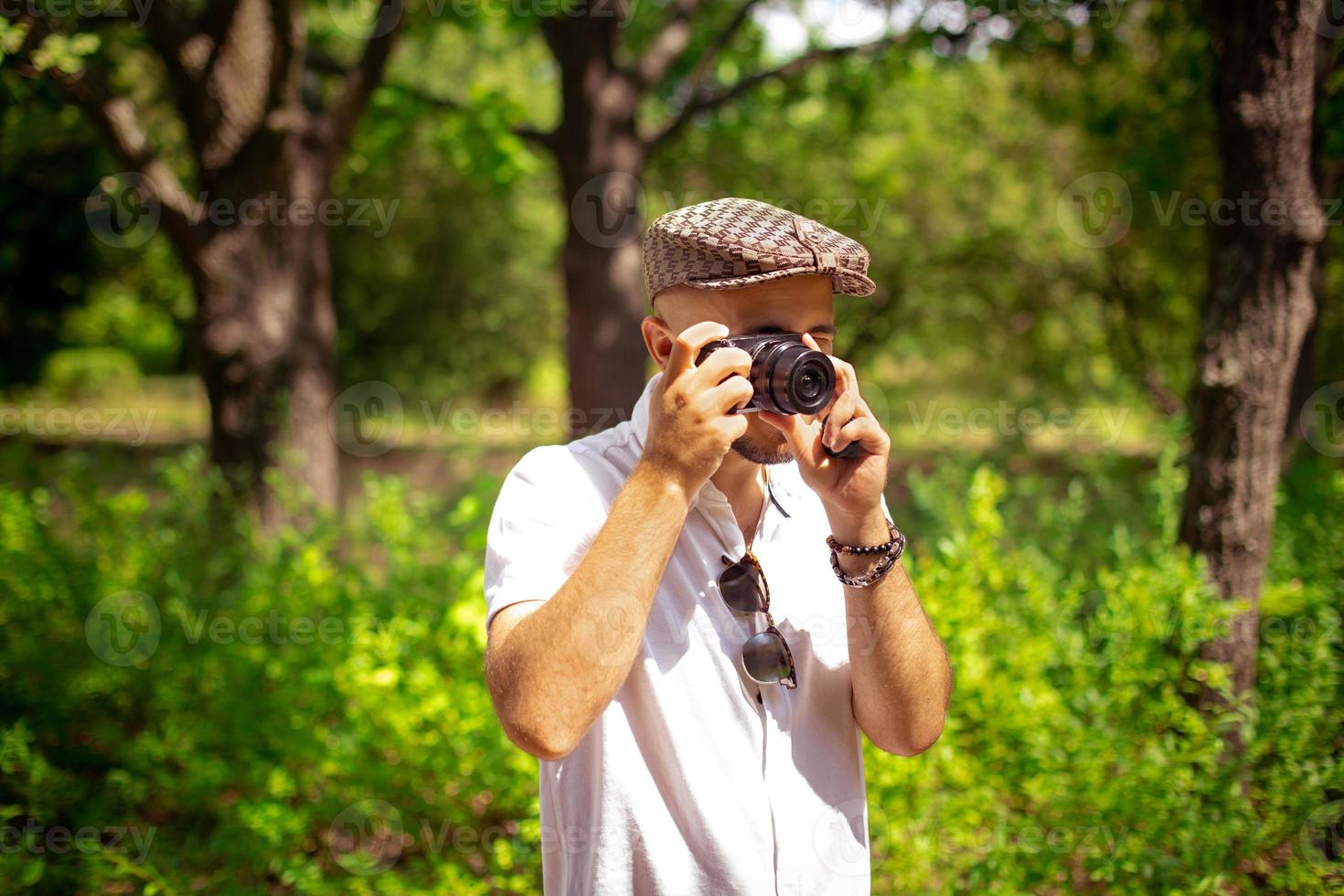 Young guy takes pictures on camera at the green park photo