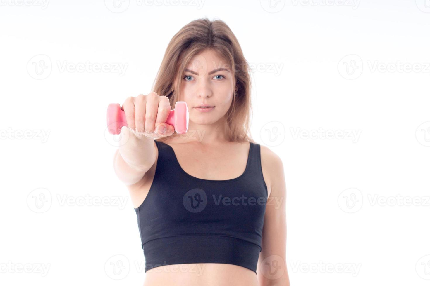 beautiful young girl in a black sports top holding  dumbbell photo