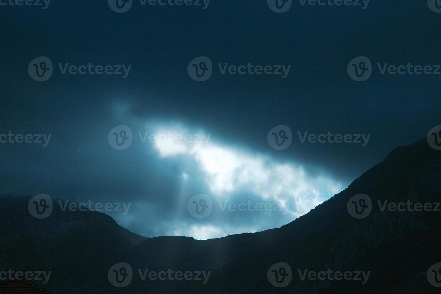 Foto de dramáticos rayos de luz empujando hacia arriba a través de las nubes