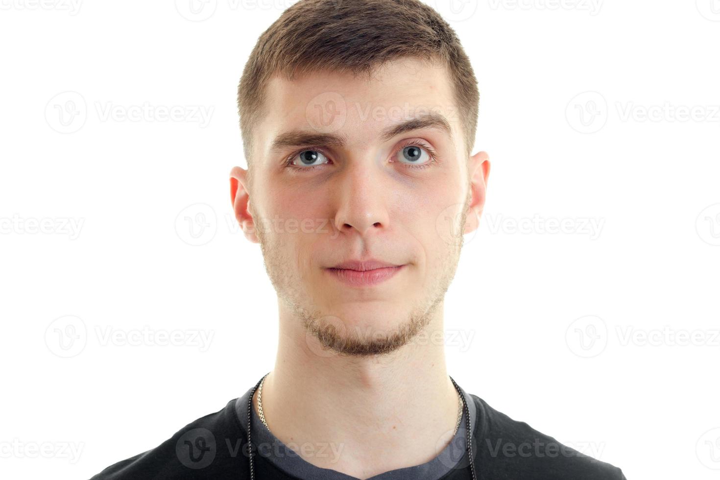 Portrait of a young handsome guy who surprised looks into a camera close-up photo