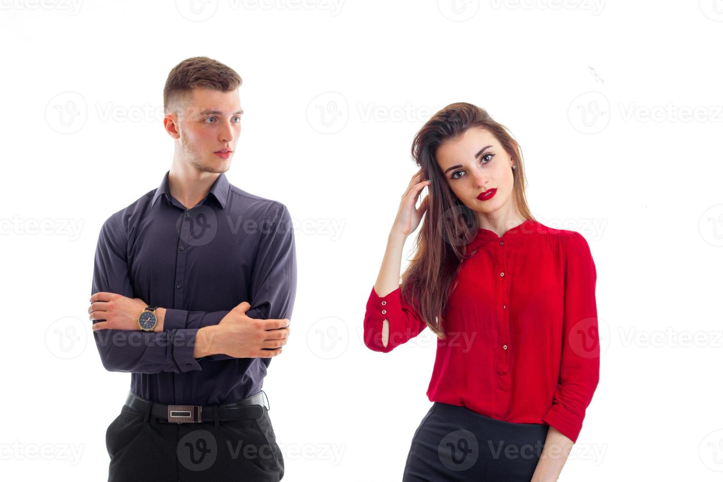 charming serious guy worth hands clasped near the beautiful girl with red lipstick and red blouse photo