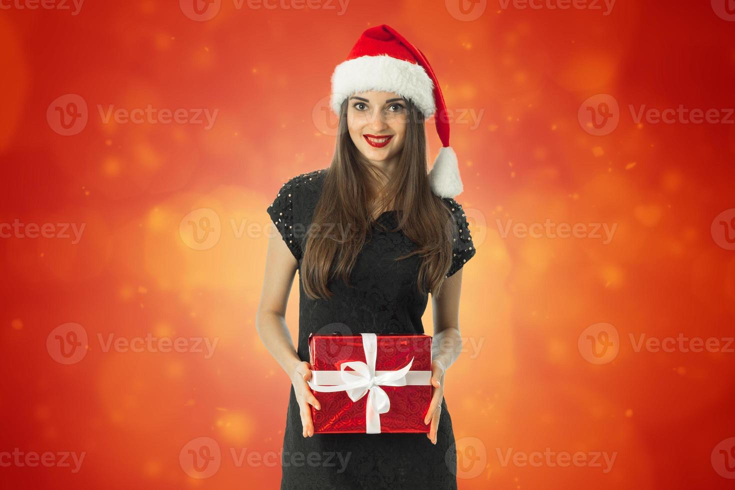 Girl in santa hat smiling and looking at the camera photo