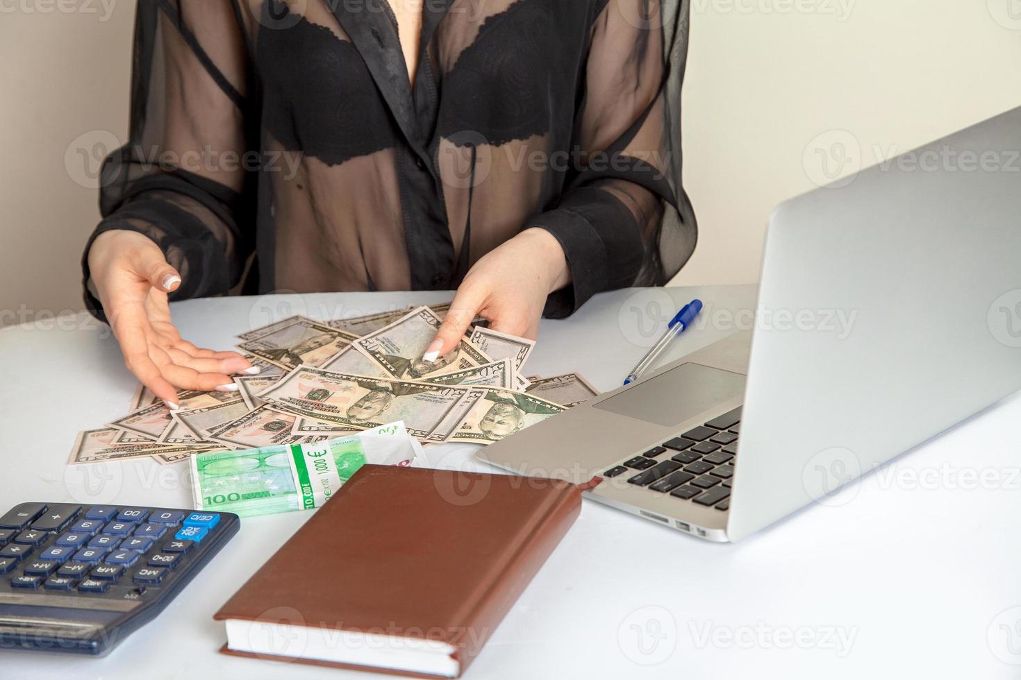 notebook laptop and a bunch of money on a white table photo