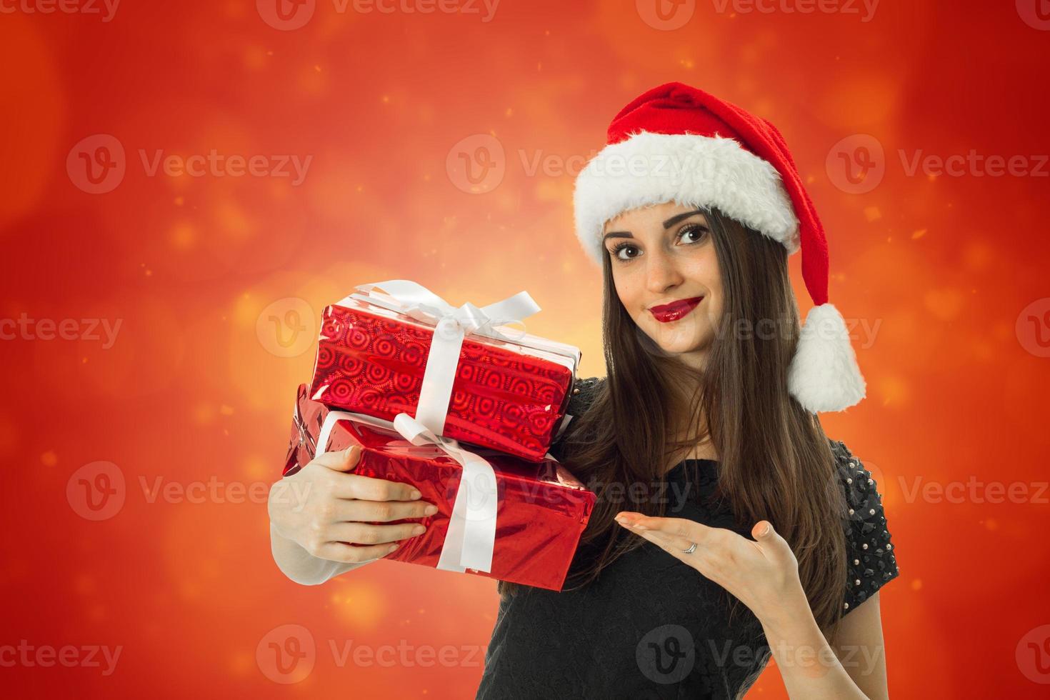 Happy girl in santa hat with red gift photo