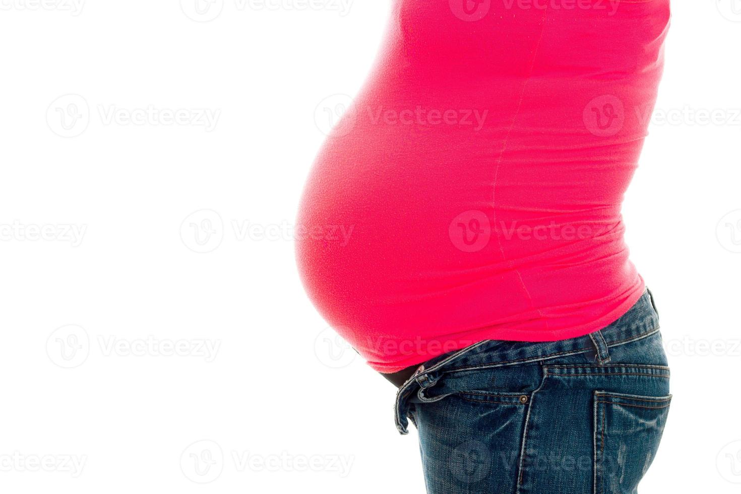profile of pregnant woman with big belly in pink shirt isolated on white background photo