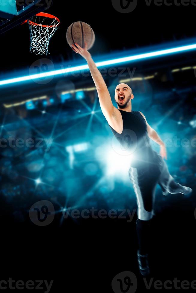 Man playing basketball and makes slam dunk on game photo