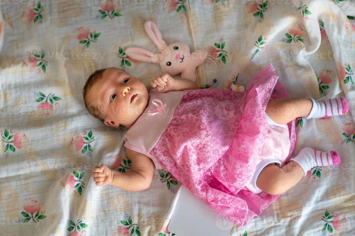 Adorable newborn girl in pink dress photo