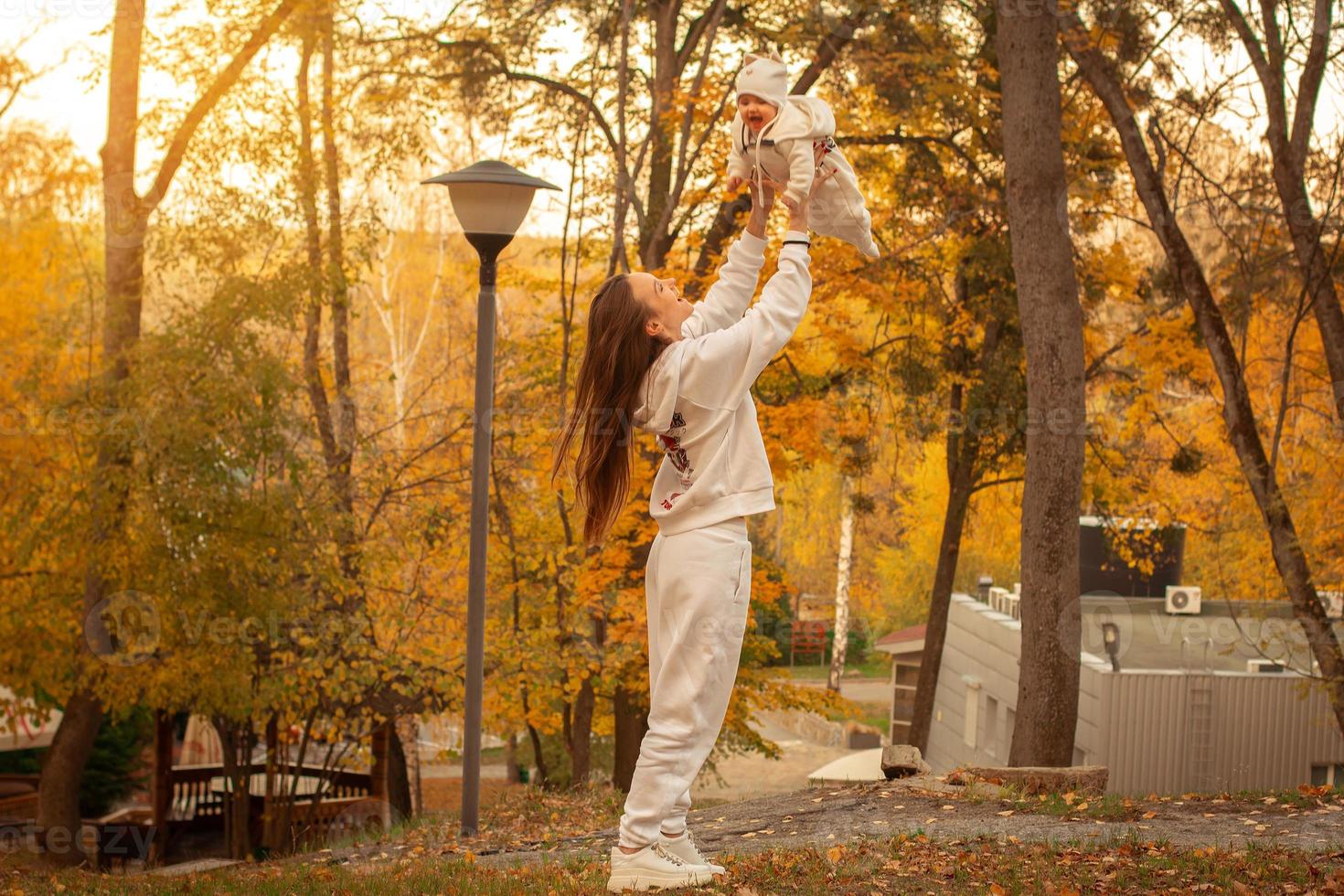 hermosa joven madre con bebé en otoño foto