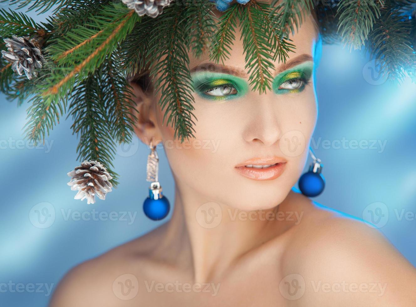 hermosa mujer joven con buen maquillaje mirando a otro lado. tiempo de Navidad. corona de navidad en la cabeza foto