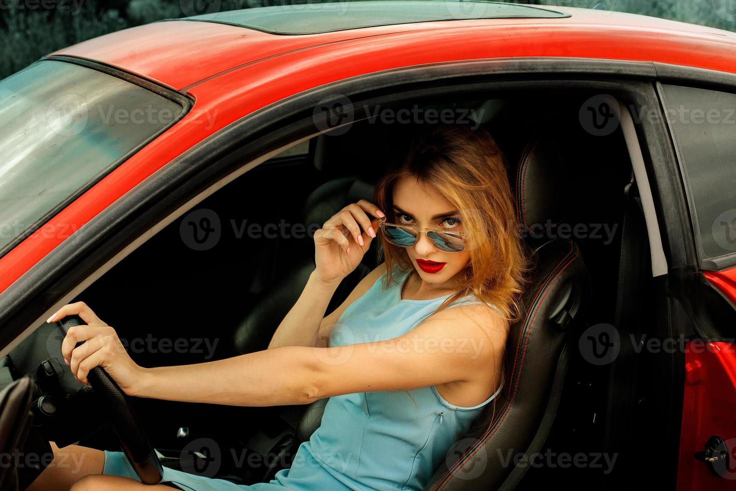 young woman with beautiful makeup sits in car photo