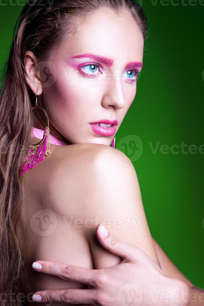 Young adult woman with pink make up on green background photo