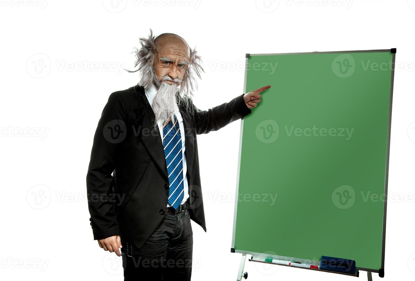 bald old teacher points on blackboard photo