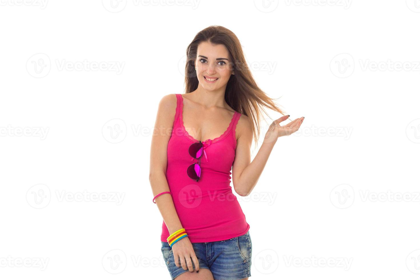 a cheerful young girl in pink t-shirt stands up straight and smiling photo