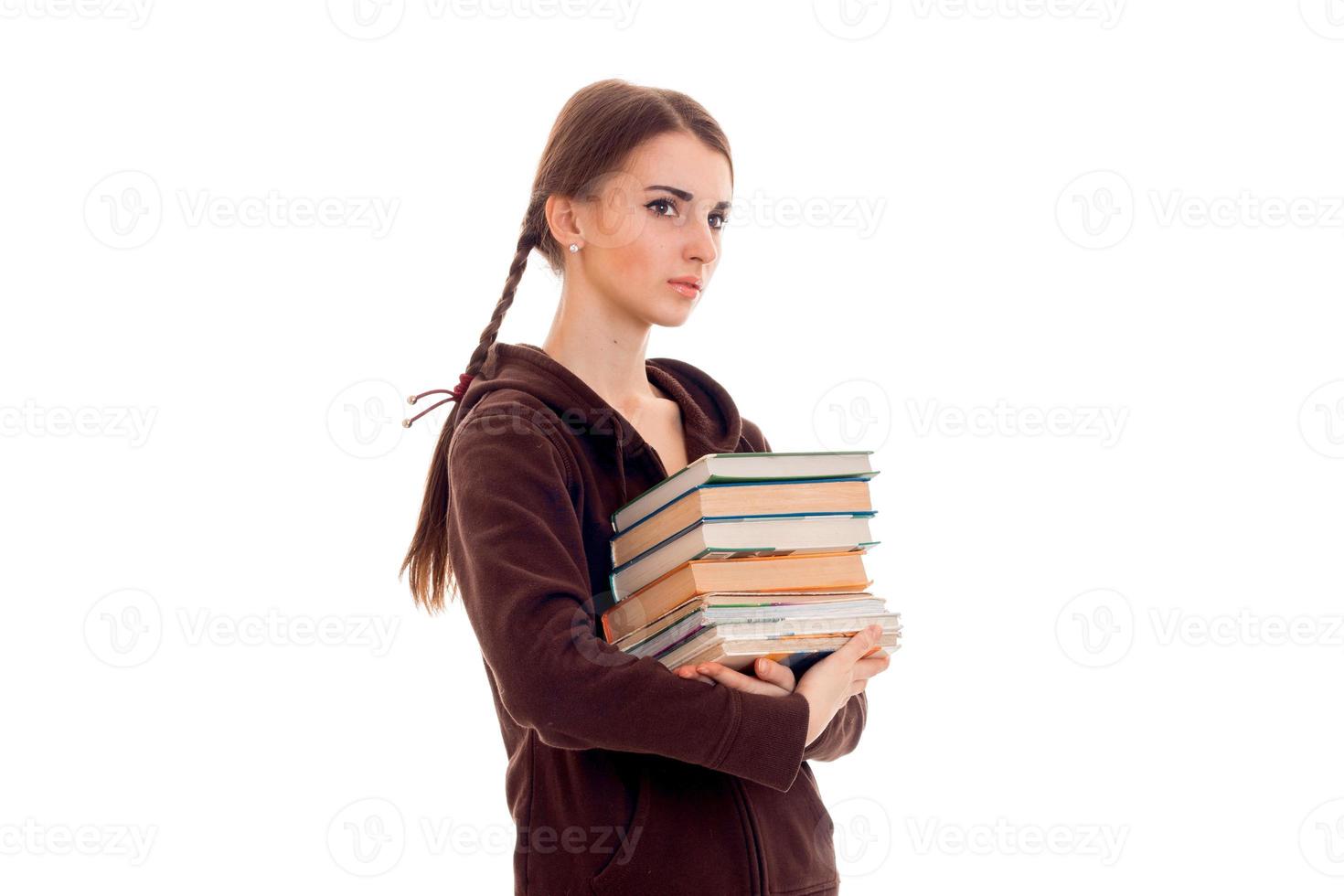 pretty young brunette student girl with a lot of books in hands isolated on white background photo