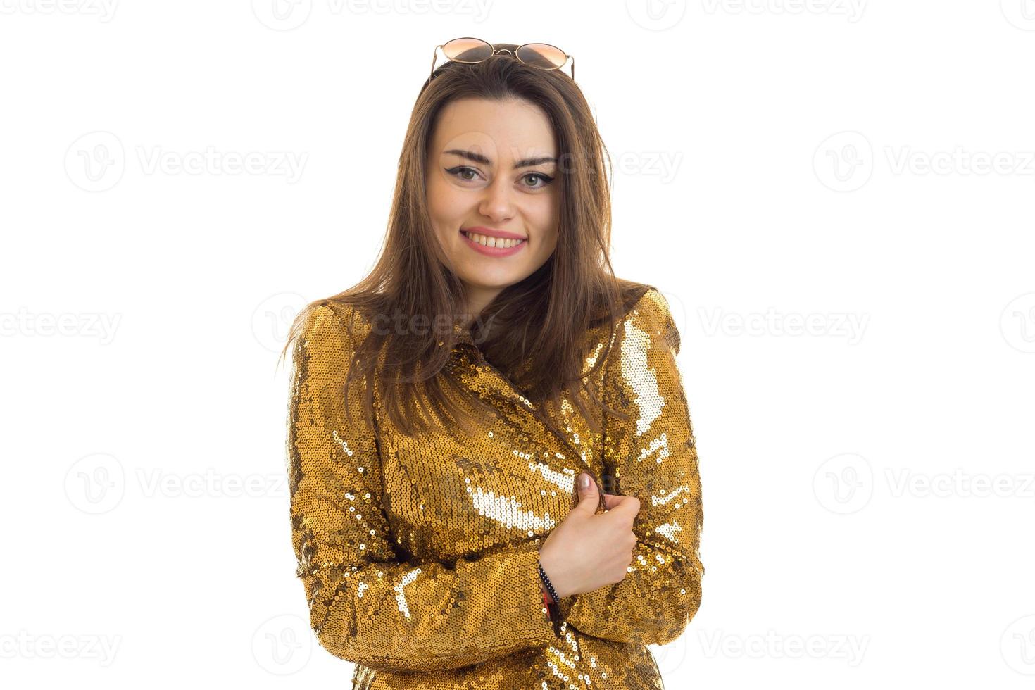 beautiful smiling Lady stands in the gold jacket and suspiciously looking at camera photo