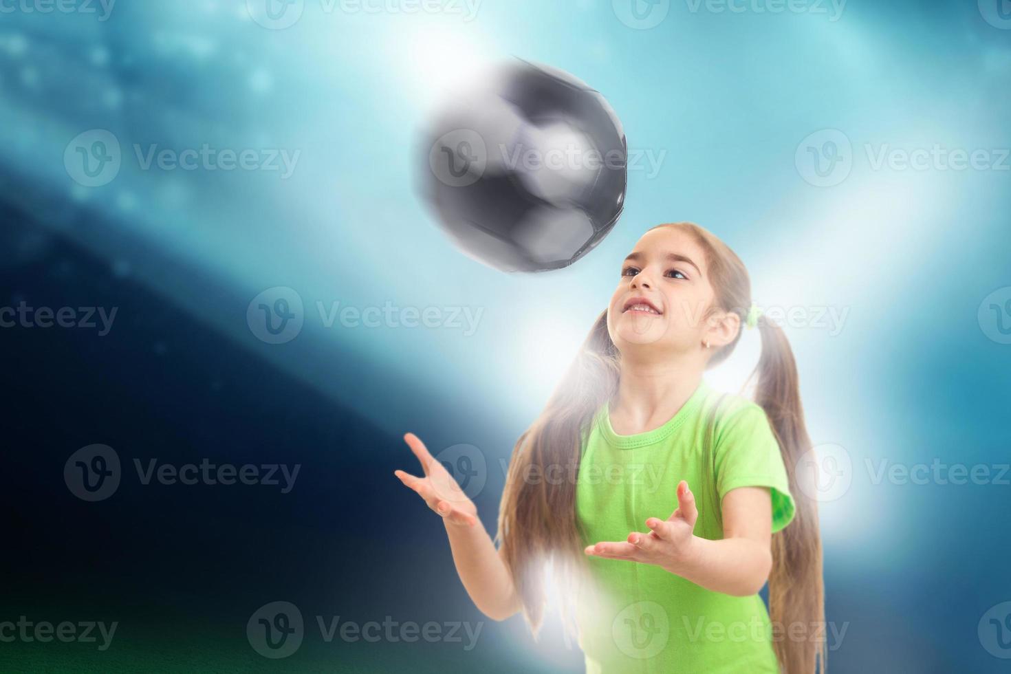 Cheerful little girl plays with soccer ball photo