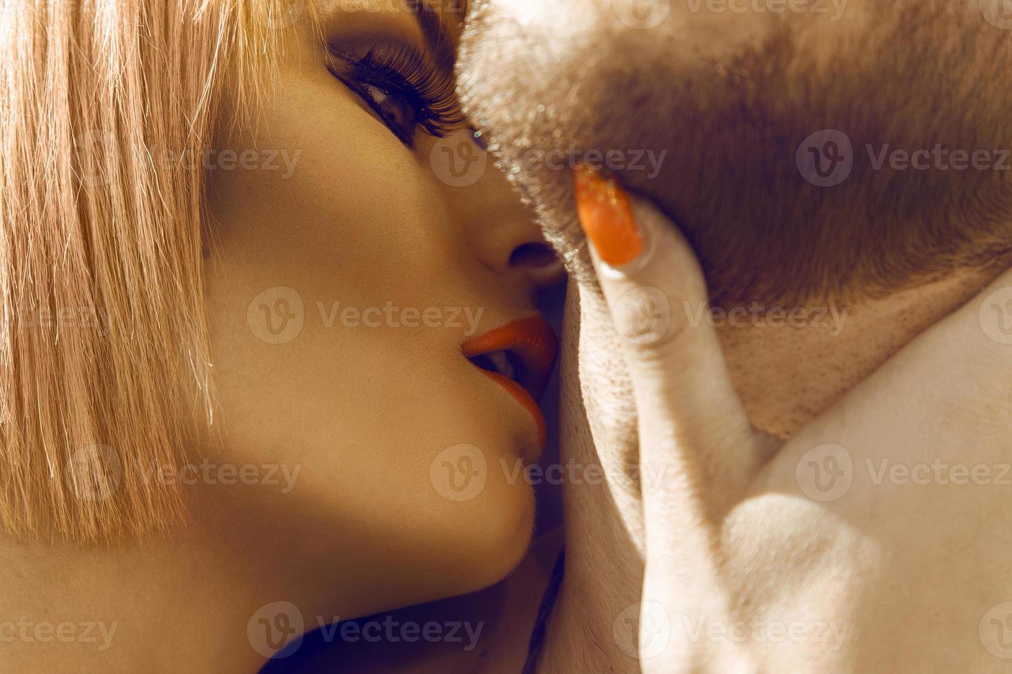 Beautiful blonde woman kissing her boyfriend in neck photo