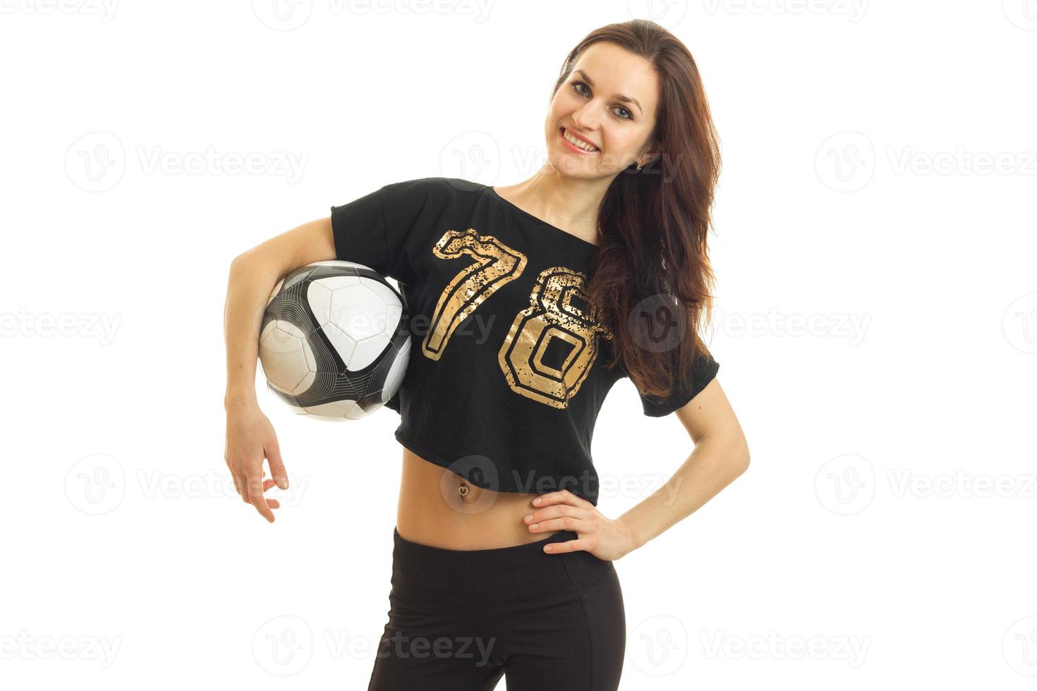 young cute brunette girl with soccer ball in her hands smiling on camera photo