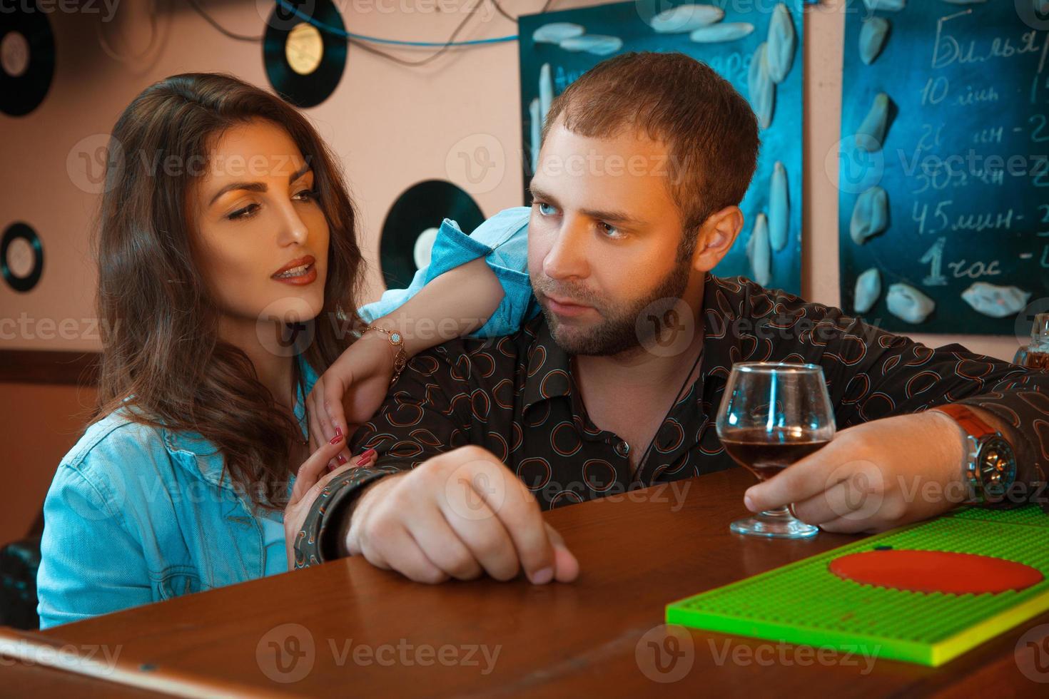 chico borracho coqueteando con una hermosa morena en un bar foto