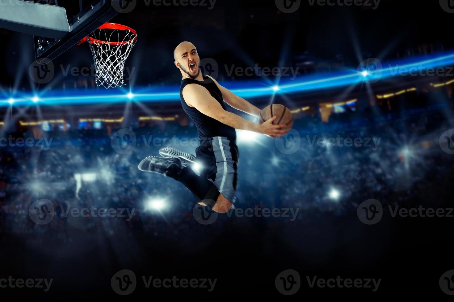 Horizontal photo of basketball player in the game makes reverse slam dunk