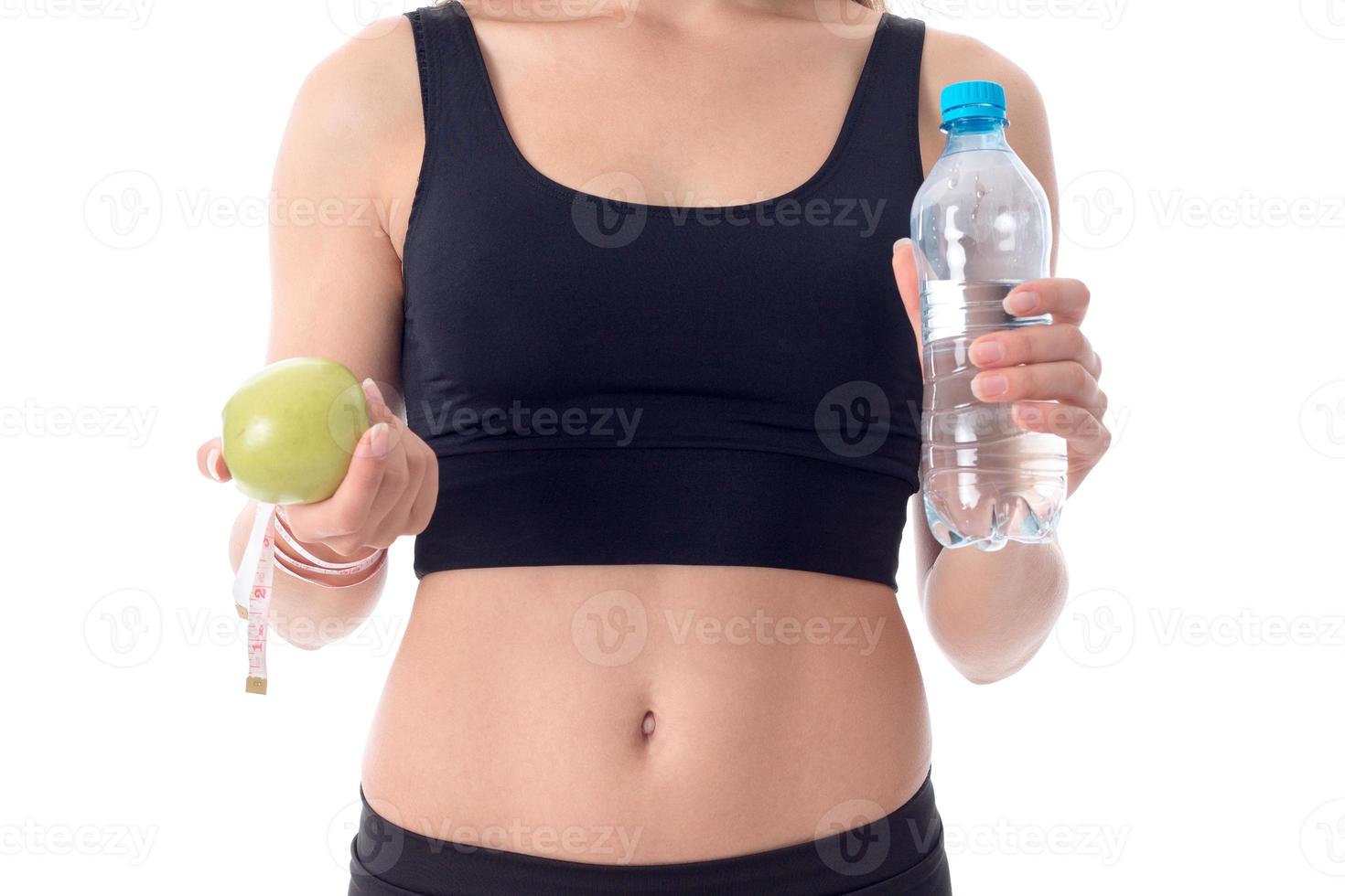 close-up of sporty girl who shows her an apple in one hand photo