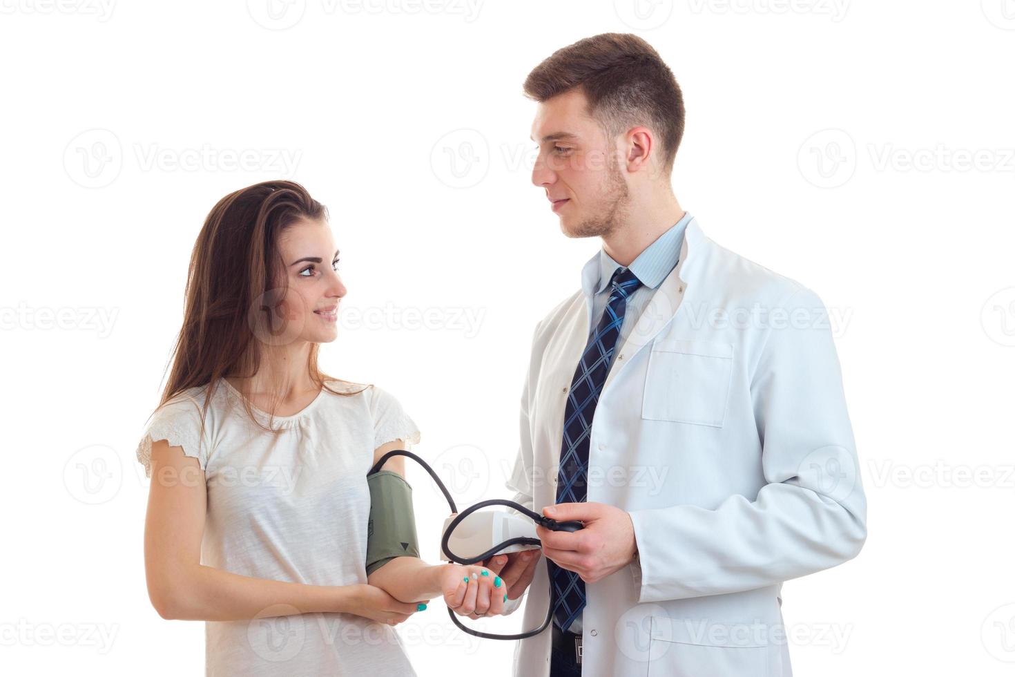 young doctor takes pressure of its patient smiling close-up photo