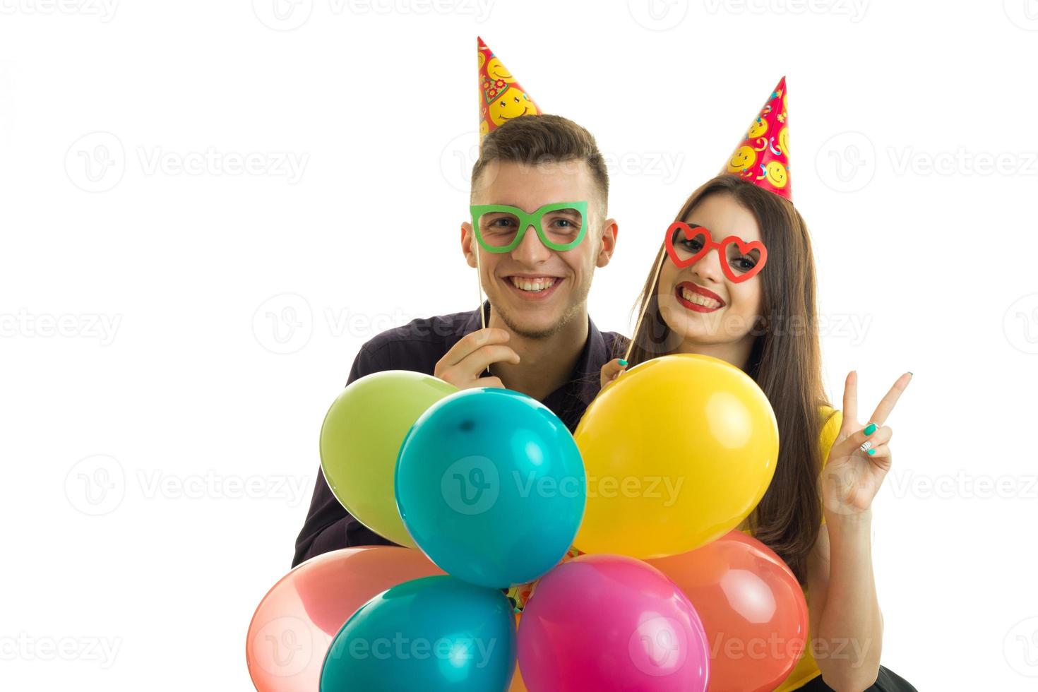retrato de una hermosa joven pareja feliz con gafas y globos en las manos foto