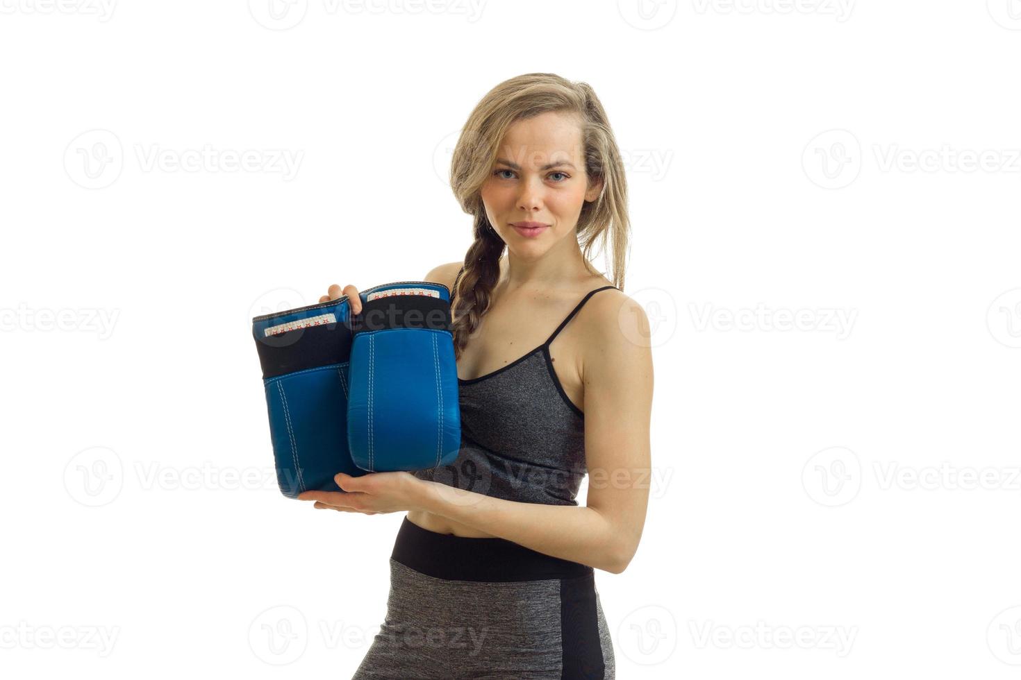 athletic girl looks into the camera and holds boxing gloves is isolated on a white background photo
