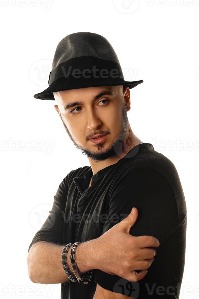 portrait of young unshaved man in hat wearing black and looking away photo