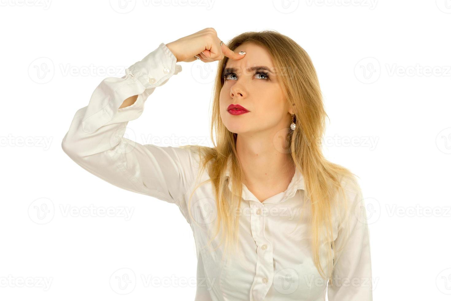 thoughtful girl put a finger to a head photo