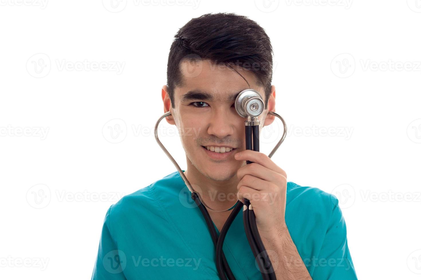 happy young brunette man doctor in blue uniform with stethoscope smiling isolated on white background photo