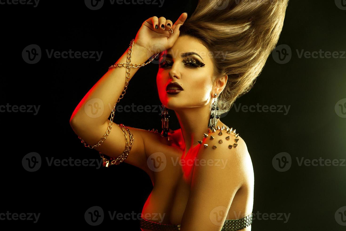 Portrait of sexual young fashionable woman with golden accessories and high straight hairstyle photo